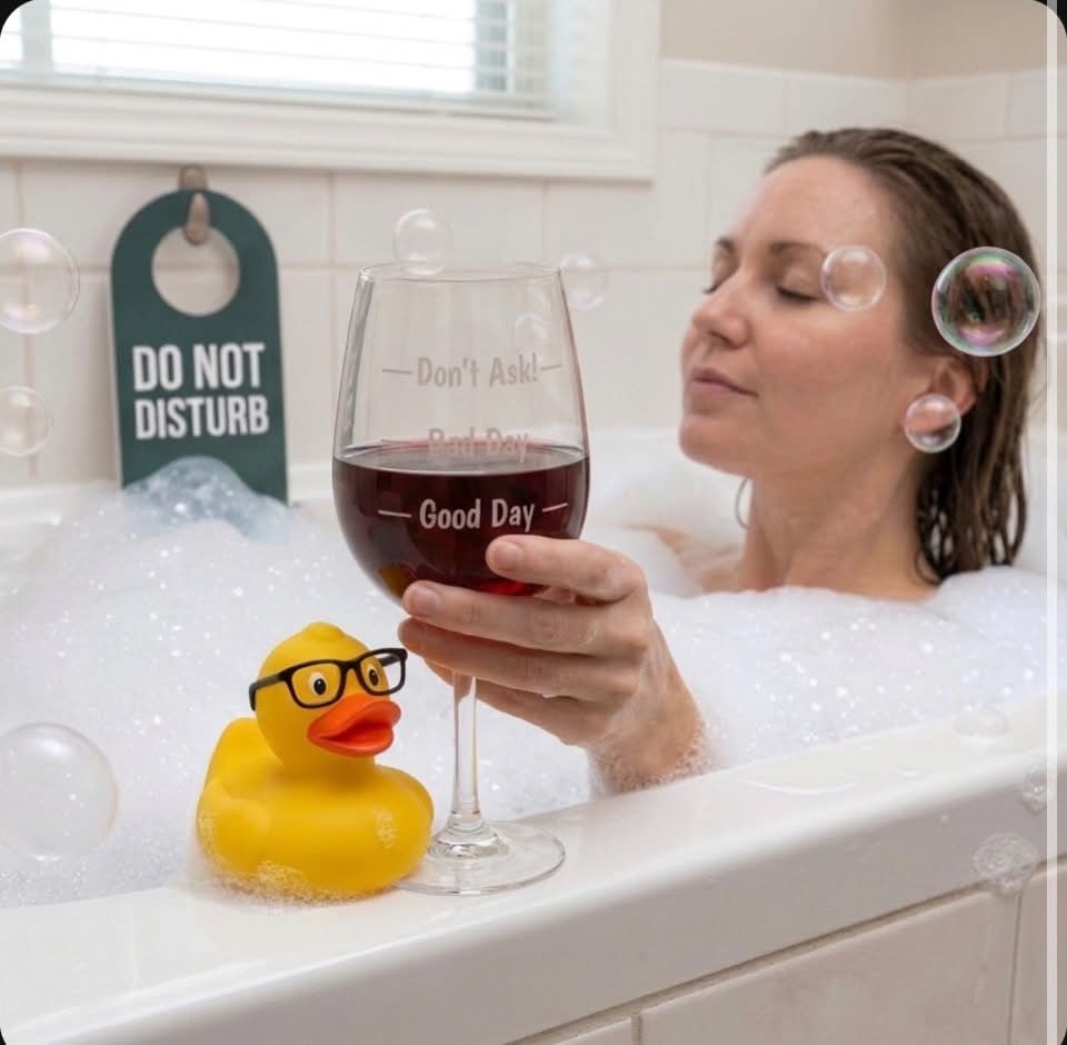 Woman relaxing in bath holding the Mood Wine Glass filled to Good Day line. Novelty wine glass with three fill lines.